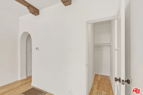 a view of a closet area with wooden floor