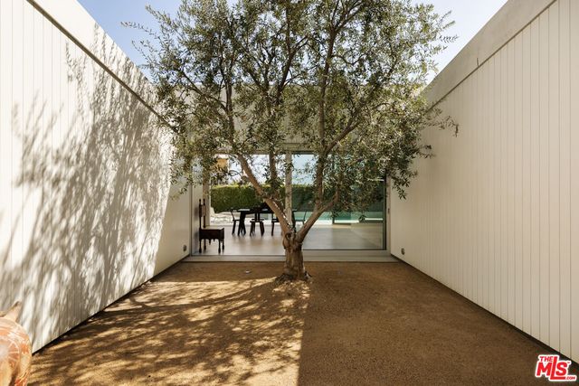a porch with a bench and trees