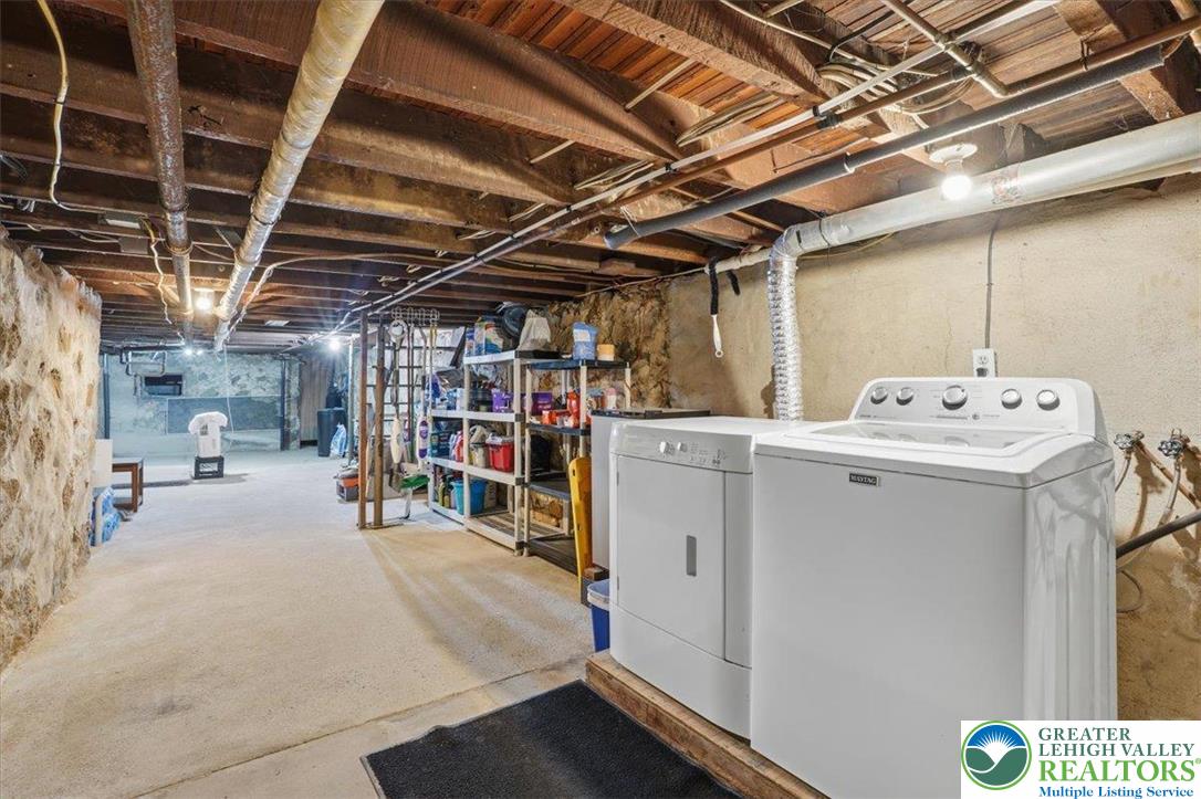 525 Ridge Street Emmaus, PA 18049 - Photo 61 of 68 This spacious utility room offers practical laundry solutions and ample storage within a sturdy basement setting.