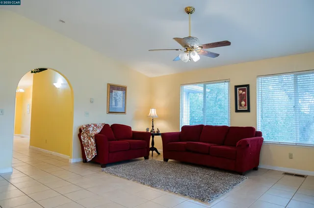 a living room with furniture a ceiling fan and a window