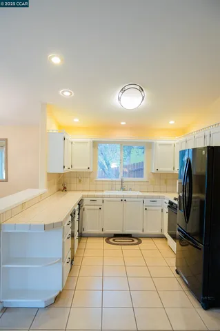 a kitchen with a sink a refrigerator and a stove top oven