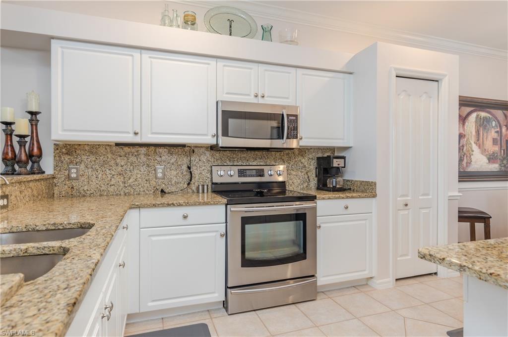 21468 Knighton Run Estero, FL 33928 - Photo 4 of 21 a kitchen with cabinets stainless steel appliances and a sink