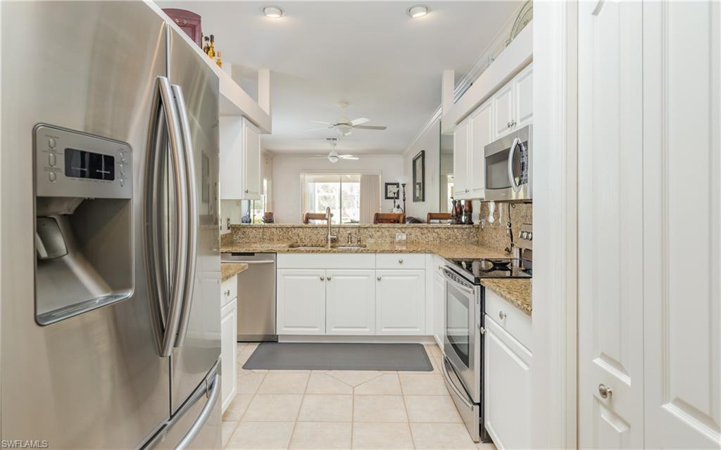 21468 Knighton Run Estero, FL 33928 - Photo 5 of 21 a kitchen with a refrigerator sink and cabinets
