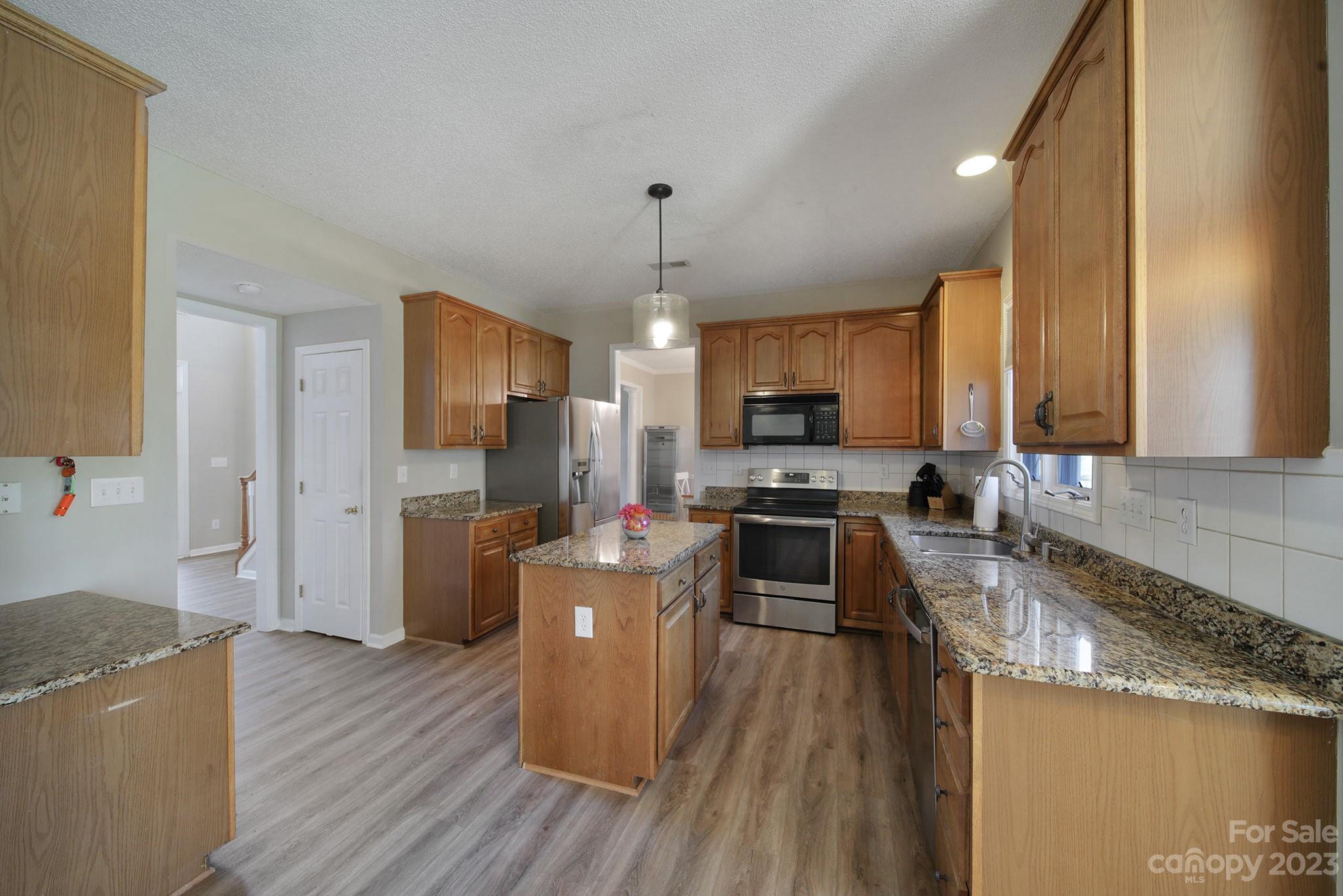 524 Whitehead Court Fort Mill, SC 29708 - Photo 11 of 45 a kitchen with a refrigerator a stove top oven a sink dishwasher and wooden cabinets with wooden floor