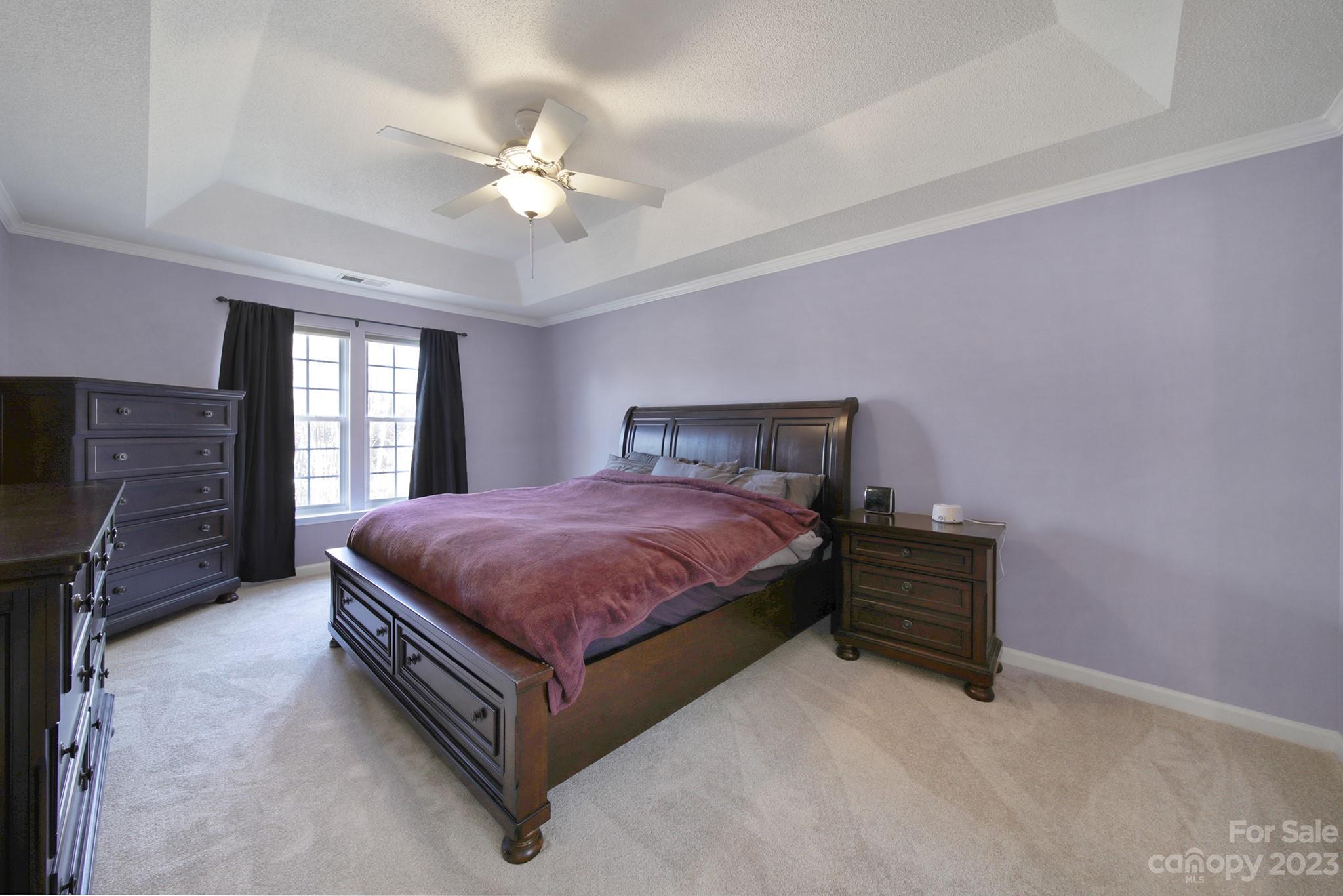 524 Whitehead Court Fort Mill, SC 29708 - Photo 20 of 45 a spacious bedroom with a bed and a chandelier