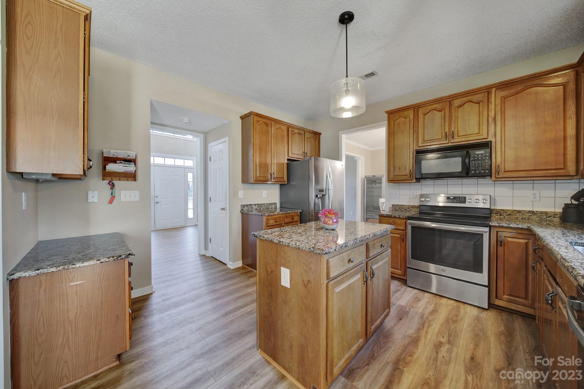 524 Whitehead Court Fort Mill, SC 29708 - Photo 9 of 45 a kitchen with stainless steel appliances granite countertop wooden floors a stove and a refrigerator