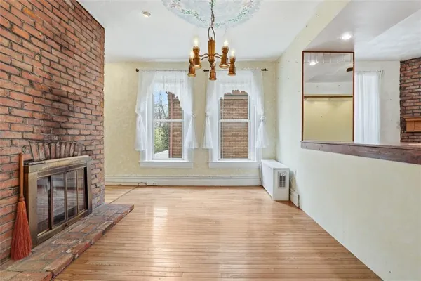 a view of a livingroom with wooden floor and a fireplace
