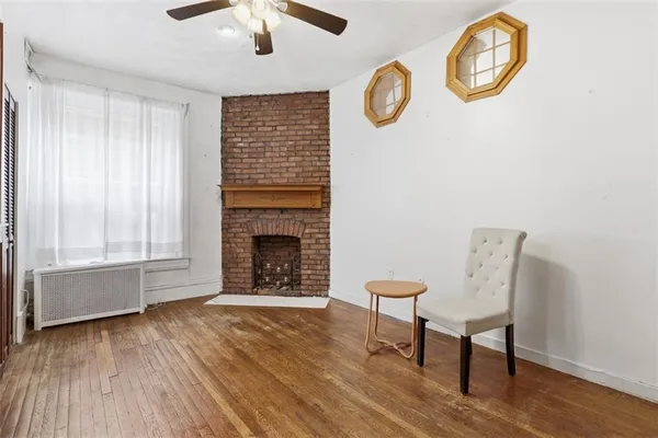 a view of an empty room with a fireplace and a window