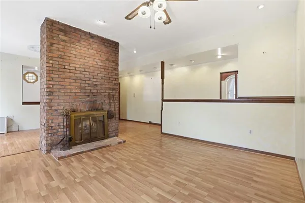 an empty room with a fireplace and wooden floor