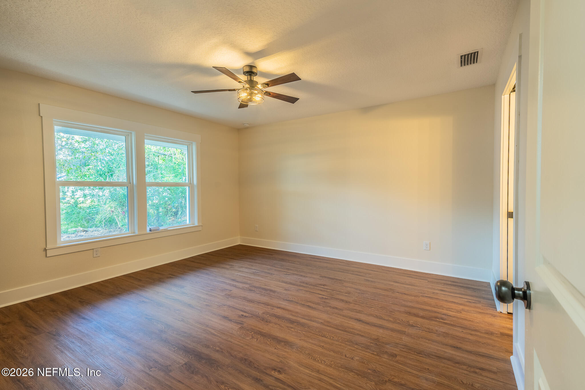 45035 James Street Callahan, FL 32011 - Photo 9 of 21 an empty room with wooden floor fan and windows
