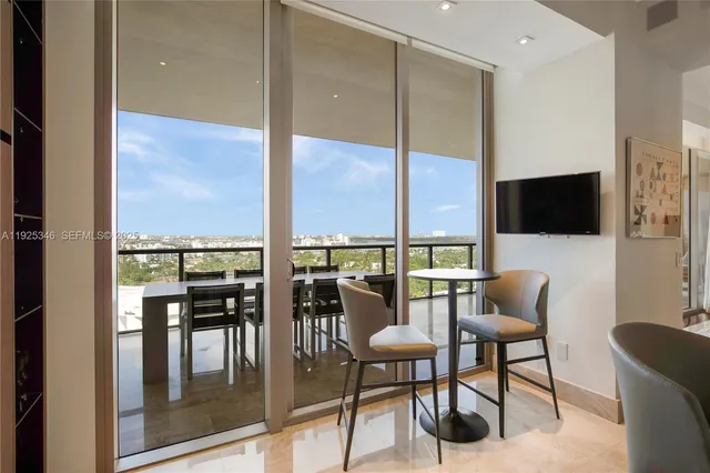 a dining room with furniture water view and a floor to ceiling window