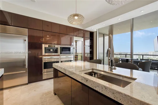 a kitchen with granite countertop a sink and stainless steel appliances