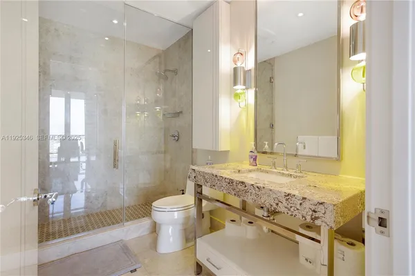 a bathroom with a granite countertop sink mirror shower and a bathtub