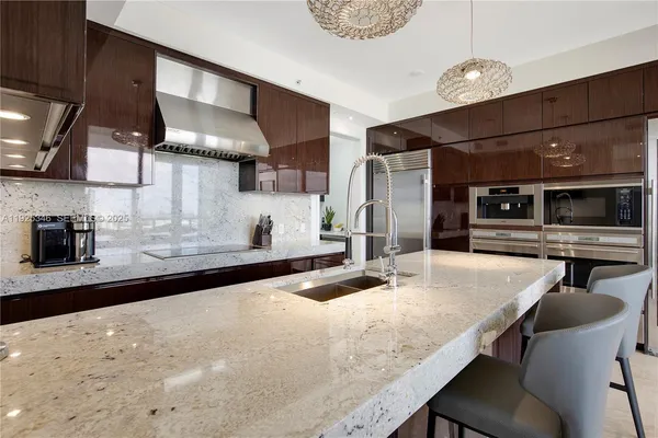 a kitchen with stainless steel appliances granite countertop a sink a stove and a refrigerator