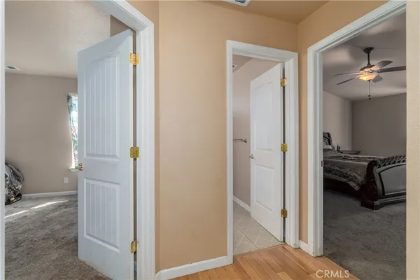 a view of a hallway with wooden floor and a bathroom