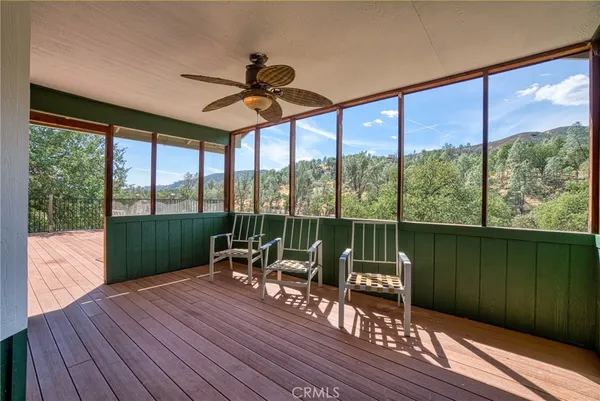 a living room with hardwood floor a ceiling fan and a large window