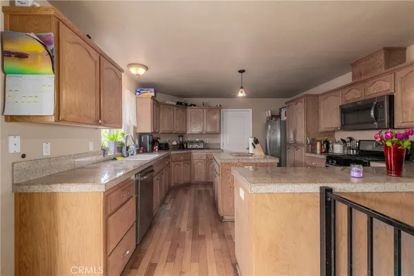 a kitchen with stainless steel appliances granite countertop a sink a stove top oven a counter space and cabinets