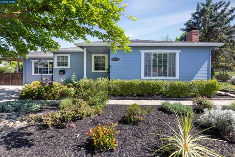 a front view of a house with a yard and potted plants