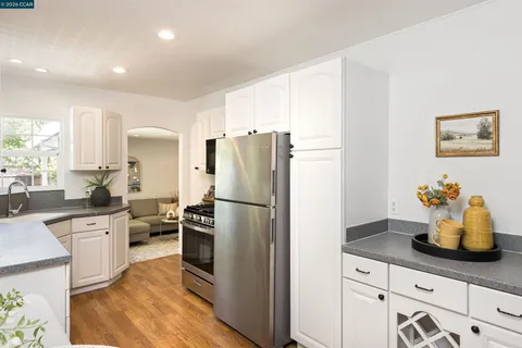 a kitchen with a refrigerator and white cabinets