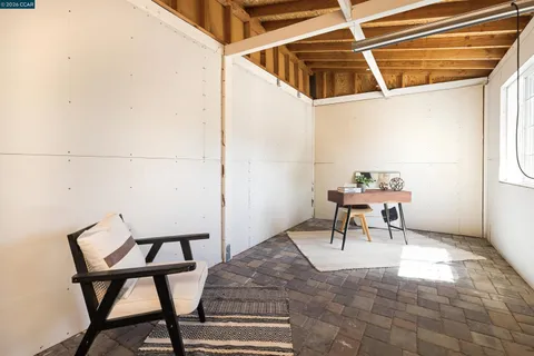 a view of a chairs and table in the back yard of a house