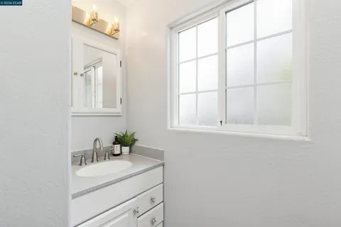 a bathroom with a sink vanity granite and a mirror