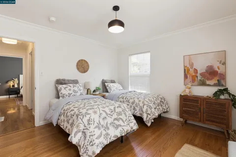a bedroom with two beds and a painting on the wall