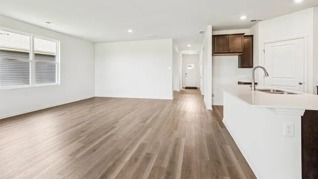 a view of a kitchen cabinets a sink and wooden floor in a room