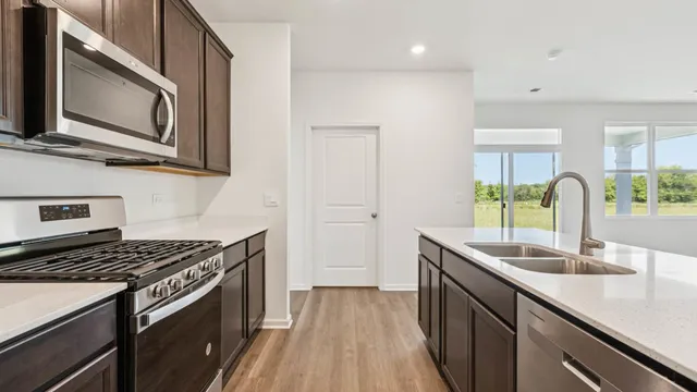 a kitchen with stainless steel appliances granite countertop a sink stove and microwave