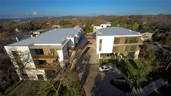an aerial view of multiple houses with a yard