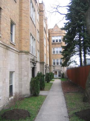 4205 West Addison Street, Unit GN Chicago, IL 60641 - Photo 1 of 1 a view of a brick building next to a yard