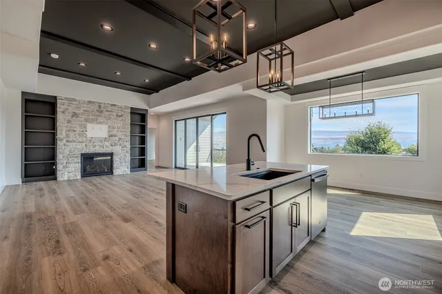 a kitchen with stainless steel appliances granite countertop a sink a stove and a wooden floors