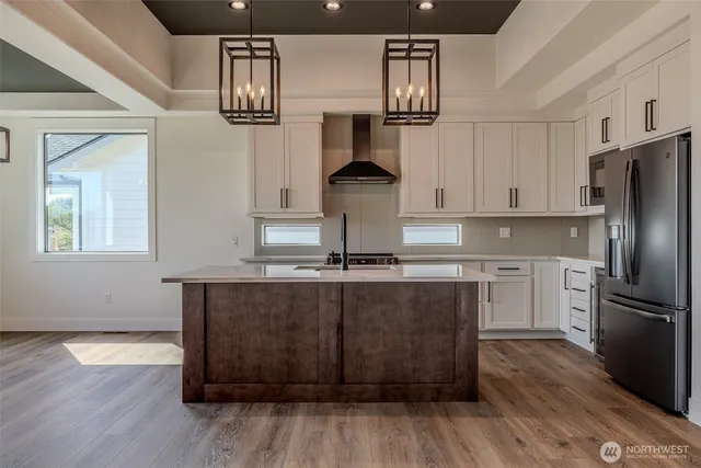 a kitchen with kitchen island granite countertop a sink cabinets and stainless steel appliances