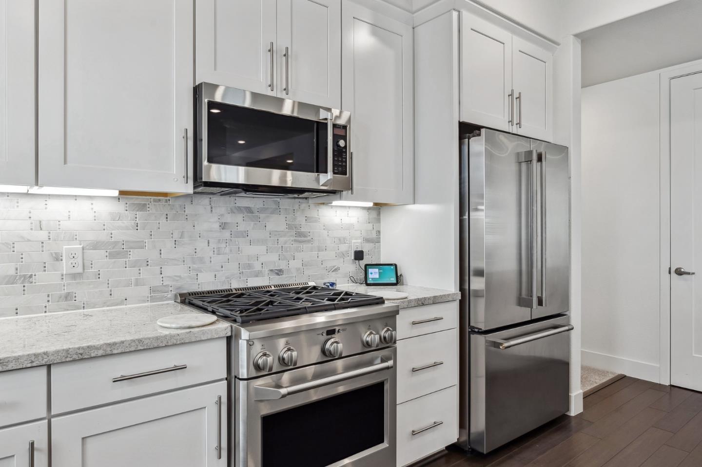 779 Eppleton Lane, Unit 304 Foster City, CA 94404 - Photo 17 of 34 a kitchen with stainless steel appliances white cabinets and a stove a refrigerator with wooden floor