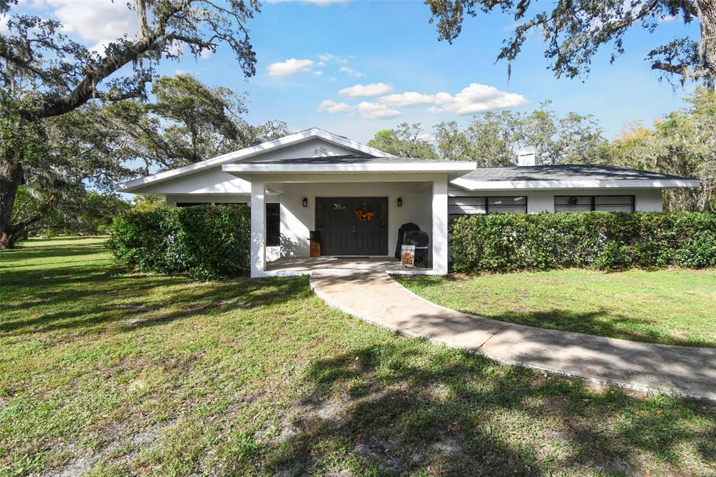 a view of a house with backyard and porch