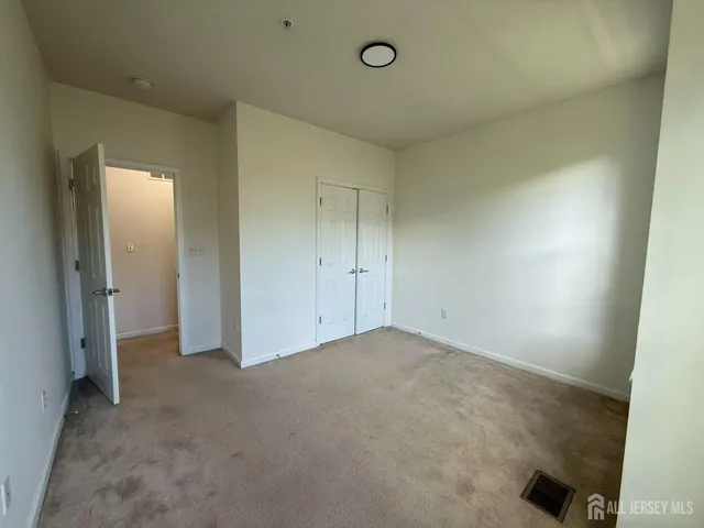 an empty room with windows and closet