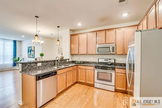 a kitchen with stainless steel appliances granite countertop a sink stove and refrigerator
