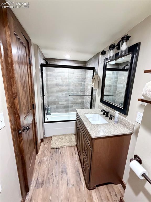 121 St Charles Drive Rye, CO 81069 - Photo 14 of 22 Bathroom with bath / shower combo with glass door, vanity, and light wood-style floors