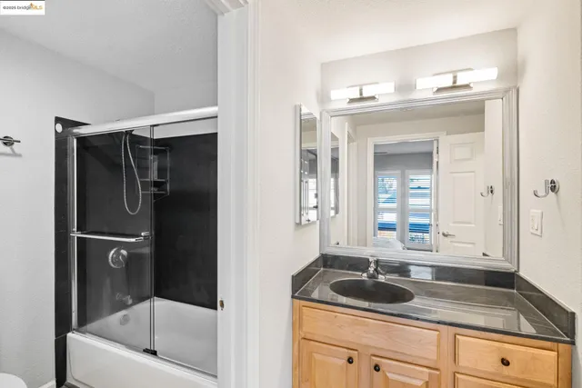 a bathroom with a granite countertop sink mirror and bathtub