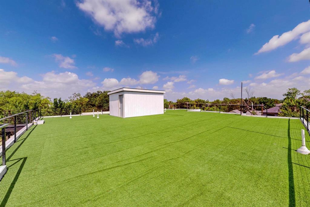 3946 North Cresthaven Road Dallas, TX 75209 - Photo 34 of 38 Expansive rooftop terrace featuring artificial turf, black metal railings, a white utility structure, and surrounding tree canopy