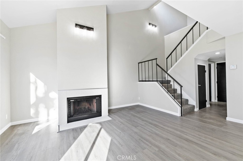 9013 Buckles Street Downey, CA 90241 - Photo 5 of 32 a view of an empty room with wooden floor fireplace and a window