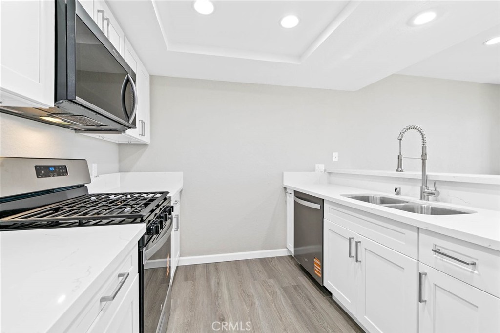 9013 Buckles Street Downey, CA 90241 - Photo 10 of 32 a kitchen with a sink stove and microwave