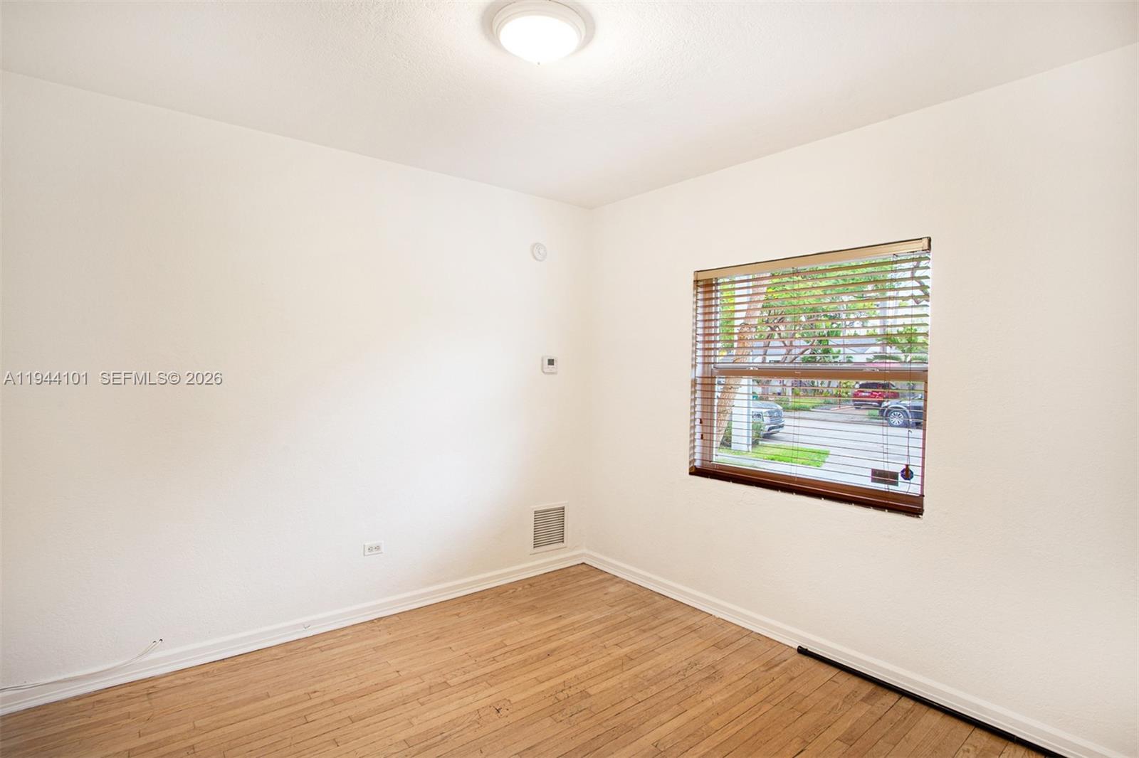 236 Southwest 28th Road Miami, FL 33129 - Photo 16 of 32 an empty room with wooden floor and windows