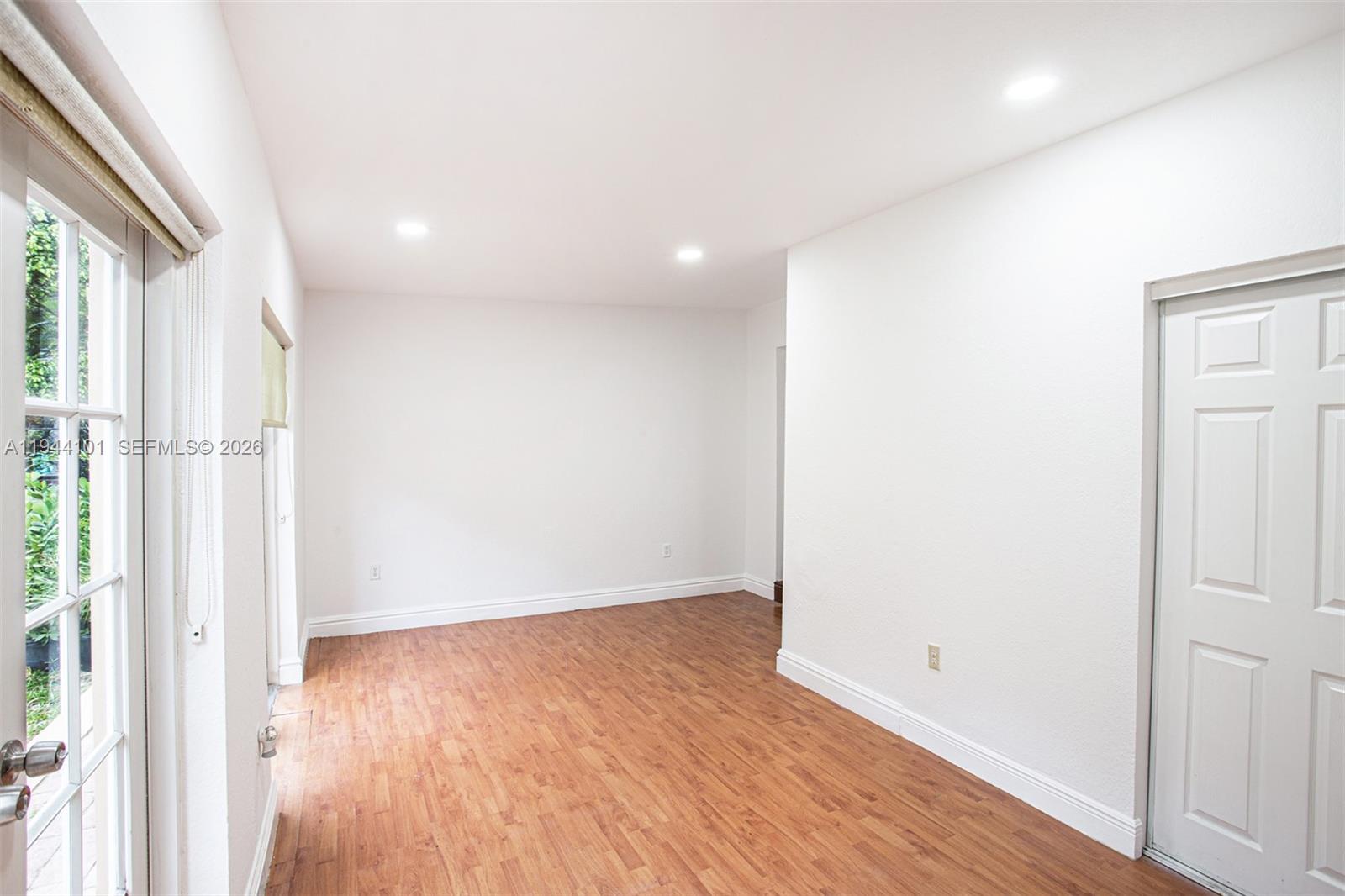 236 Southwest 28th Road Miami, FL 33129 - Photo 8 of 32 an empty room with wooden floor and entrance