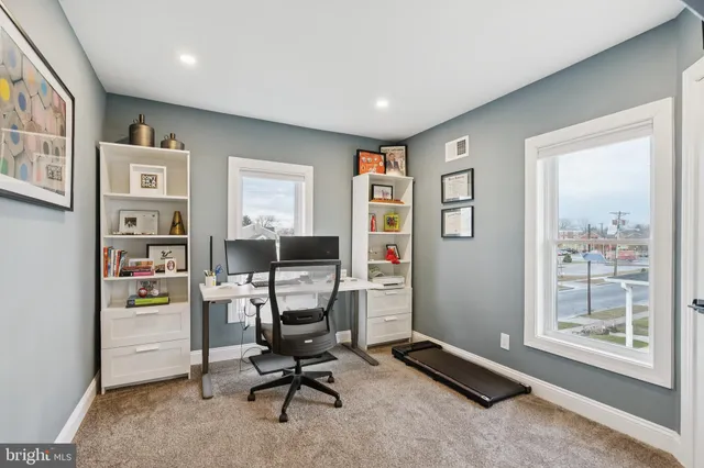 a view of a workspace with furniture and a window