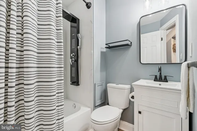 a bathroom with a toilet a sink and mirror