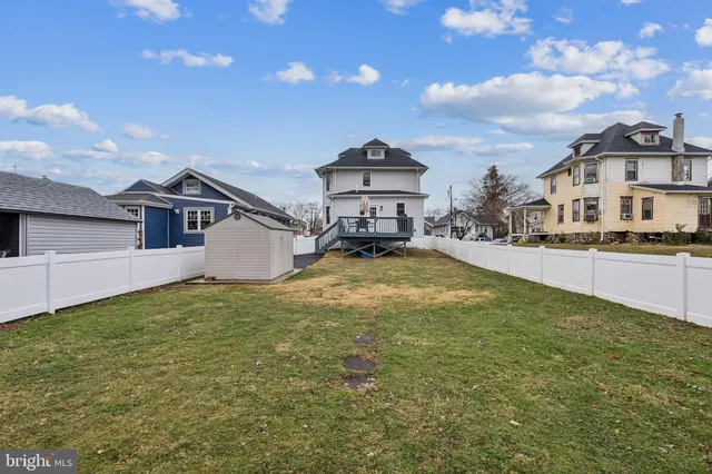 a view of a house with a wooden deck and a backyard