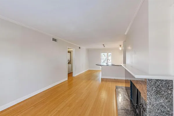 a kitchen with stainless steel appliances granite countertop a sink a microwave and wooden floor