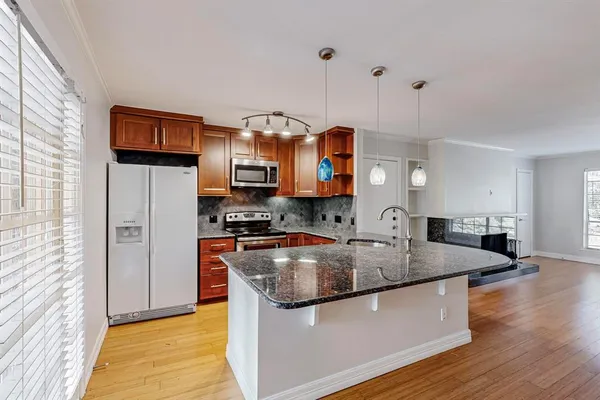 a kitchen with stainless steel appliances granite countertop a stove a sink and a microwave