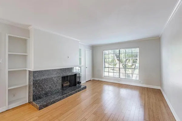 a view of empty room with wooden floor and fireplace