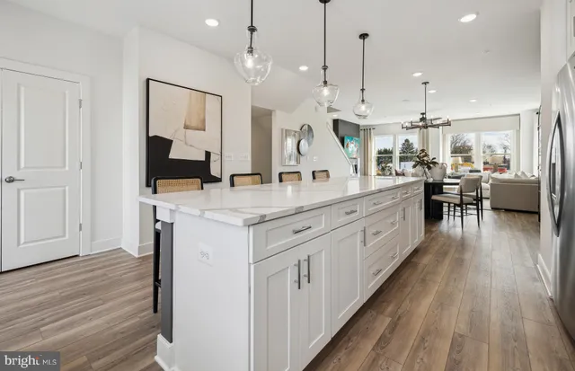 a large white kitchen with lots of counter space wooden floor and appliances